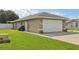 The exterior of the house has a large two car garage and a well manicured lawn at 8219 Rangers Path, Lakeland, FL 33809