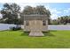 Backyard storage shed with double doors and a wood ramp entrance at 8219 Rangers Path, Lakeland, FL 33809