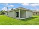 Back exterior of the home featuring a sliding glass door to the porch and freshly cut grass at 1025 Lakewood Ct, Lakeland, FL 33801