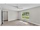 This bright bedroom offers wood-look floors, a ceiling fan, and a large window looking out to the yard at 1025 Lakewood Ct, Lakeland, FL 33801