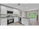 Modern kitchen featuring white cabinets, stainless steel appliances, and granite countertops at 1025 Lakewood Ct, Lakeland, FL 33801