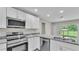 Stylish kitchen featuring granite countertops, stainless steel appliances, and white cabinetry at 1025 Lakewood Ct, Lakeland, FL 33801
