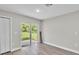 Spacious living room with wood floors and a sliding glass door with a backyard view at 1025 Lakewood Ct, Lakeland, FL 33801