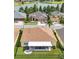 Aerial view of a yellow house with a private backyard, patio, and mature trees near a lake at 2472 Tahoe Dr, Lakeland, FL 33805