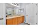 Well-lit bathroom features dual sinks, a large mirror, and light wood cabinetry at 2472 Tahoe Dr, Lakeland, FL 33805