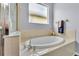 Bright bathroom with oval soaking tub, neutral tile surround, and natural light from the privacy window at 2472 Tahoe Dr, Lakeland, FL 33805