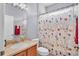 Bathroom featuring floral shower curtain, neutral vanity with silver faucet and light fixture and a mirror at 2472 Tahoe Dr, Lakeland, FL 33805