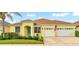 Charming single-story home featuring a well-manicured lawn, two-car garage, and a cheerful yellow facade at 2472 Tahoe Dr, Lakeland, FL 33805