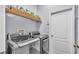 Well-equipped laundry room featuring modern washer and dryer, plus storage shelves at 2472 Tahoe Dr, Lakeland, FL 33805