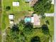 Aerial view features property with a pool, outbuildings, and lush greenery enhancing the private retreat at 2700 Park Ave, Indian Lake Estates, FL 33855