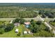 Aerial view displays property with a pool, multiple outbuildings, and a picturesque, tree-lined setting at 2700 Park Ave, Indian Lake Estates, FL 33855