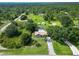 Aerial view features property with a pool, outbuildings, and a beautiful, tree-filled surrounding landscape at 2700 Park Ave, Indian Lake Estates, FL 33855