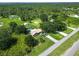 Aerial view showcases a charming home with pool, outbuildings, and a beautiful, tree-filled surrounding landscape at 2700 Park Ave, Indian Lake Estates, FL 33855