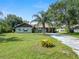 Charming home with well-maintained lawn and mature trees, set back from driveway and extra storage buildings at 2700 Park Ave, Indian Lake Estates, FL 33855