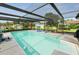 Enjoyable screened-in pool area with outdoor seating, a basketball hoop, and lush greenery at 2700 Park Ave, Indian Lake Estates, FL 33855