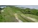 Scenic waterfront view featuring a grassy bank, a lake, and diverse vegetation at 2700 Park Ave, Indian Lake Estates, FL 33855
