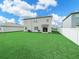 Spacious backyard featuring lush green grass, privacy fence and a two-story home at 2811 Grandbury Grove, Lakeland, FL 33811