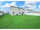 Large backyard featuring lush green grass, a privacy fence and a modern two-story home at 2811 Grandbury Grove, Lakeland, FL 33811