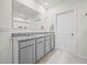 Bathroom with double vanity, gray cabinets, and a large mirror, with neutral tile floors at 2811 Grandbury Grove, Lakeland, FL 33811