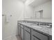 Bright bathroom featuring granite countertops, double sinks, gray cabinets and a large mirror at 2811 Grandbury Grove, Lakeland, FL 33811