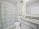 Well-lit bathroom featuring a shower with floral curtain, granite sink, and a mirrored cabinet at 2811 Grandbury Grove, Lakeland, FL 33811