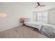 Bright bedroom featuring a modern bed frame, ceiling fan and a large window with natural light at 2811 Grandbury Grove, Lakeland, FL 33811