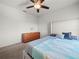 Carpeted bedroom featuring a bed, dresser, and ceiling fan with a light fixture at 2811 Grandbury Grove, Lakeland, FL 33811