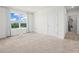 Bright, carpeted bedroom with natural light from a large window offering lovely neighborhood views at 2811 Grandbury Grove, Lakeland, FL 33811