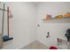 Functional laundry area equipped with shelving, a wall-mounted rack and tile flooring at 2811 Grandbury Grove, Lakeland, FL 33811