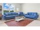 Bright living room with blue sofas, large window, and decorative accents at 2811 Grandbury Grove, Lakeland, FL 33811