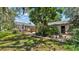 Charming backyard features a deck, fire pit, mature trees, and lush landscaping for relaxing outdoor living at 423 Avenue H Se, Winter Haven, FL 33880