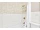 Close up of bathroom with white tiles, brass hardware and a shower featuring patterned mosaic tile detail at 423 Avenue H Se, Winter Haven, FL 33880