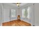 Bedroom with hardwood floors, ceiling fan, white walls, two windows and white sheer curtains at 423 Avenue H Se, Winter Haven, FL 33880