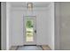View of an entryway featuring a white door with glass window, shiplap walls and a ceiling light fixture at 423 Avenue H Se, Winter Haven, FL 33880