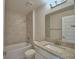 Bathroom featuring a tub with tiled walls, a granite-look countertop, a white toilet, and a mirror at 5298 Tennessee Ridge Ct, Auburndale, FL 33823