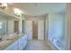 This bathroom with dual sinks, granite counters and access to the closet and tub offers a spa-like experience at 5298 Tennessee Ridge Ct, Auburndale, FL 33823