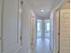 Hallway featuring wood-look tile floors, neutral walls, and multiple white doors leading to different rooms at 5298 Tennessee Ridge Ct, Auburndale, FL 33823