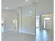 Open-concept living space with light tile flooring leading to the front door and kitchen at 5298 Tennessee Ridge Ct, Auburndale, FL 33823