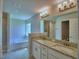 Bright bathroom features dual sinks with granite countertops, a soaking tub, and a separate shower at 5427 Waterside Dr, Auburndale, FL 33823
