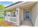 Inviting front porch with white railing, a blue front door, and stone pavers at 5427 Waterside Dr, Auburndale, FL 33823