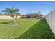 Expansive backyard with a screened-in pool, tropical landscaping, and a secure privacy fence at 5611 Aral Dr, Lakeland, FL 33805