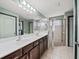 Bathroom with double vanity, large mirror, and glass-enclosed shower at 5611 Aral Dr, Lakeland, FL 33805
