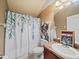 Bathroom with decorative shower curtain, artwork, and wooden vanity at 5611 Aral Dr, Lakeland, FL 33805