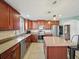 Modern kitchen with cherry wood cabinets, tiled backsplash, stainless steel appliances, and an island at 5611 Aral Dr, Lakeland, FL 33805