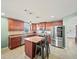 Stylish kitchen featuring cherry wood cabinets, stainless steel appliances, a center island, and tiled flooring at 5611 Aral Dr, Lakeland, FL 33805