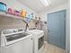 Bright laundry room with washer, dryer, and storage shelf at 5611 Aral Dr, Lakeland, FL 33805