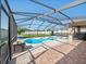 This screened-in pool area with tile patio overlooks the landscaped yard at 5611 Aral Dr, Lakeland, FL 33805