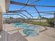 View of the screened-in pool and spa, with a spacious backyard, perfect for outdoor activities at 5611 Aral Dr, Lakeland, FL 33805