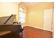 Music room featuring a piano, hardwood floors, large window with natural light, suitable for hobbyists at 6408 Christina Chase Pl, Lakeland, FL 33813