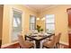 A modern dining room features a table set for six with white chairs and natural light streaming through the windows at 6408 Christina Chase Pl, Lakeland, FL 33813